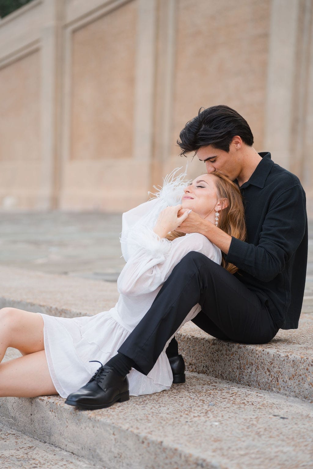 Couple reclining on stone steps forehead kiss engagement