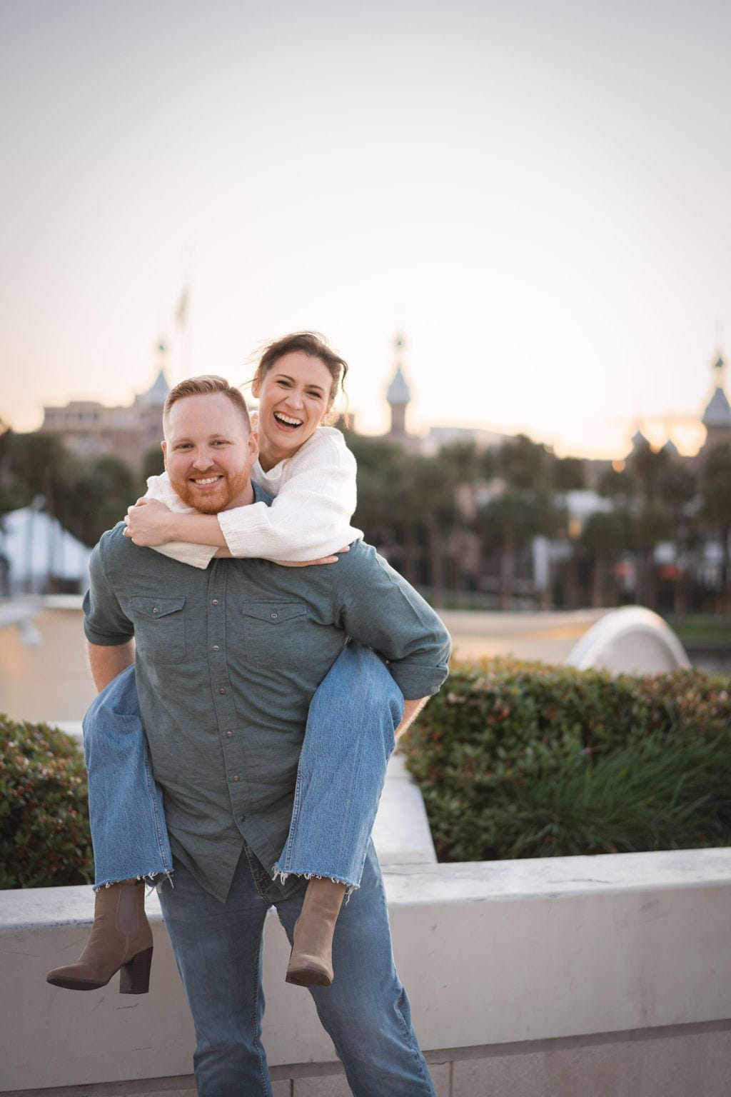 Engaged couple piggyback laughing University Tampa minarets