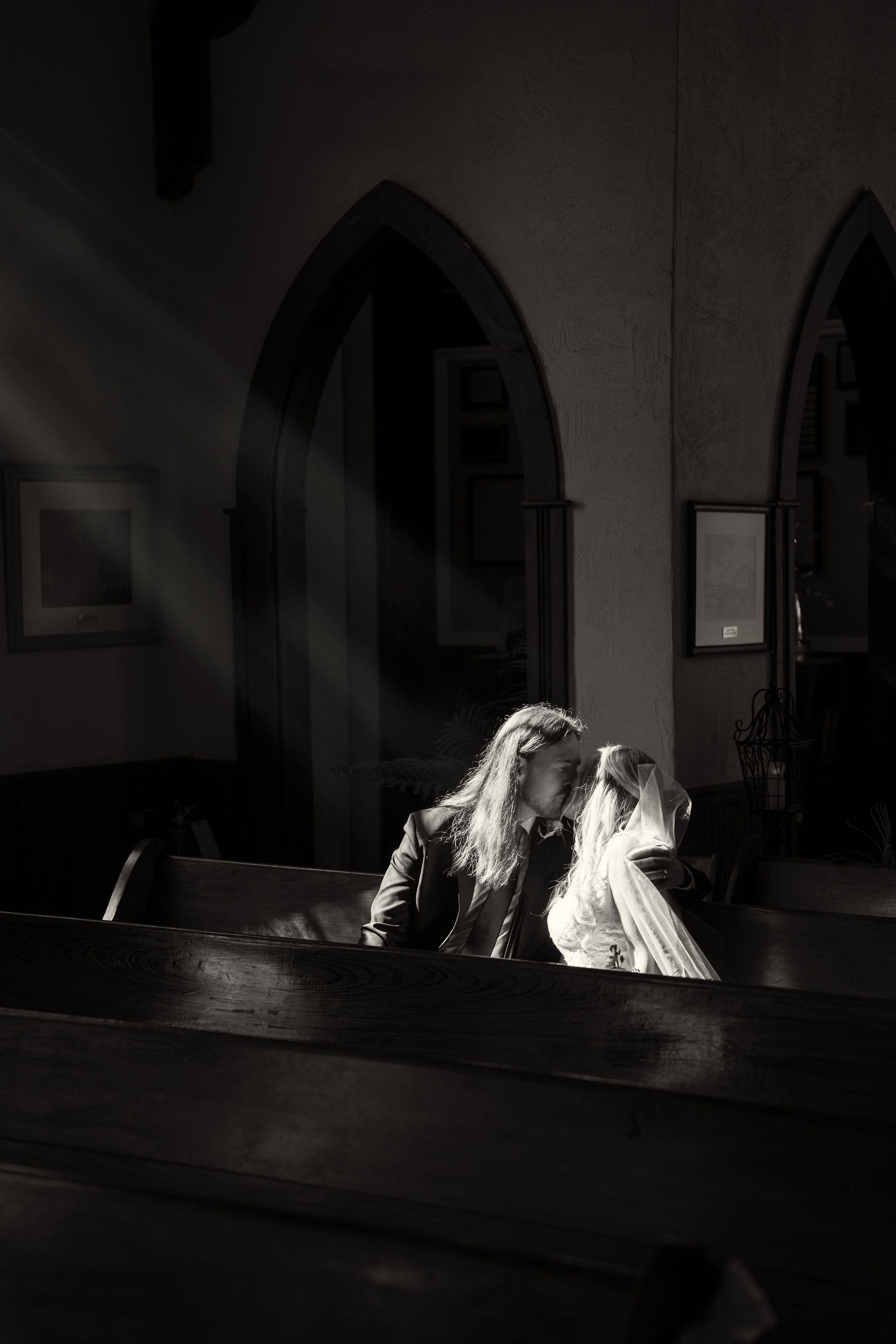 Bride groom church sunbeam kiss black and white