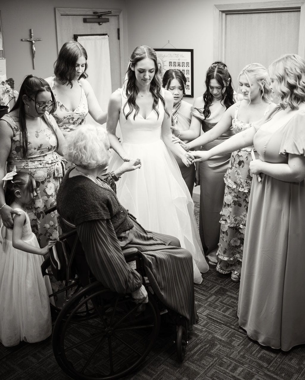 Bridesmaids praying over bride before wedding ceremony
