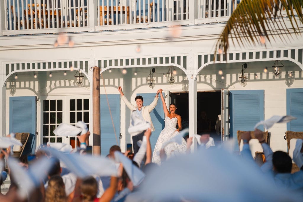 Bride and groom grand entrance guests waving napkins