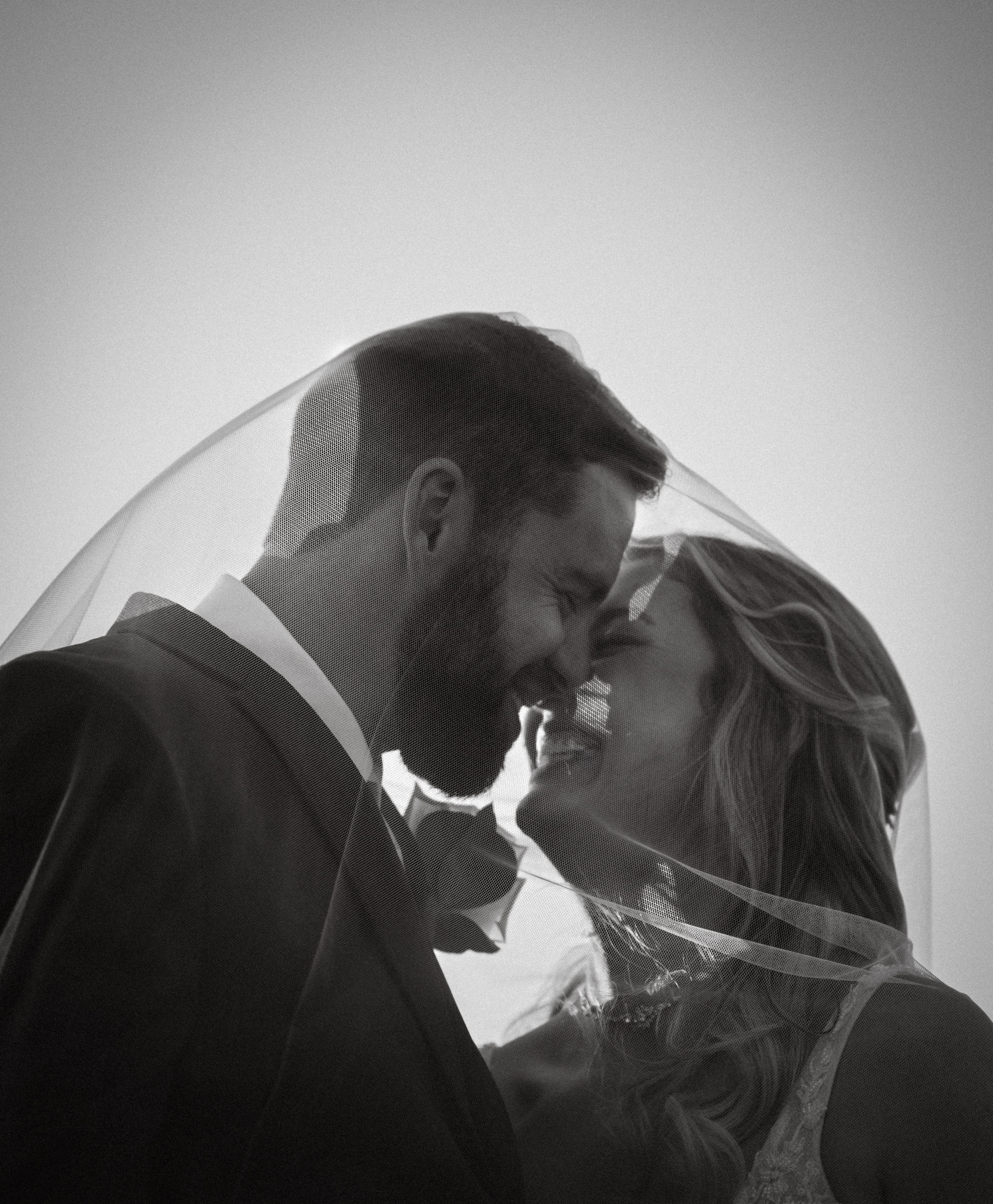 Black and white veil couple nose to nose