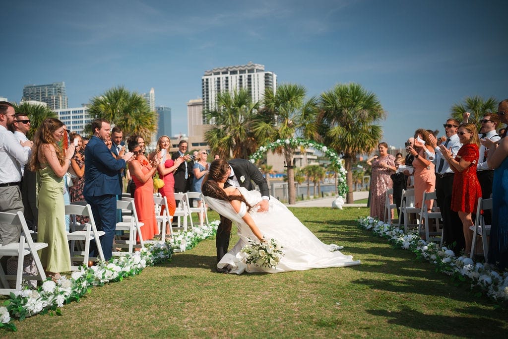 Bride and groom recessional dip kiss downtown Tampa skyline