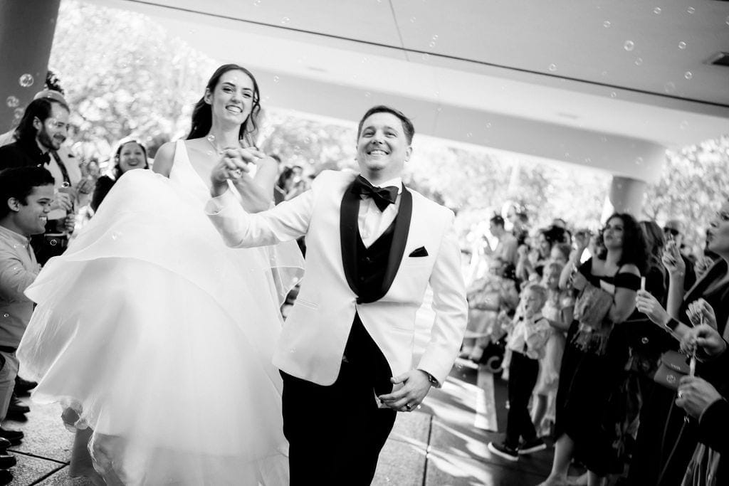 Bride and groom bubble exit guests cheering after ceremony