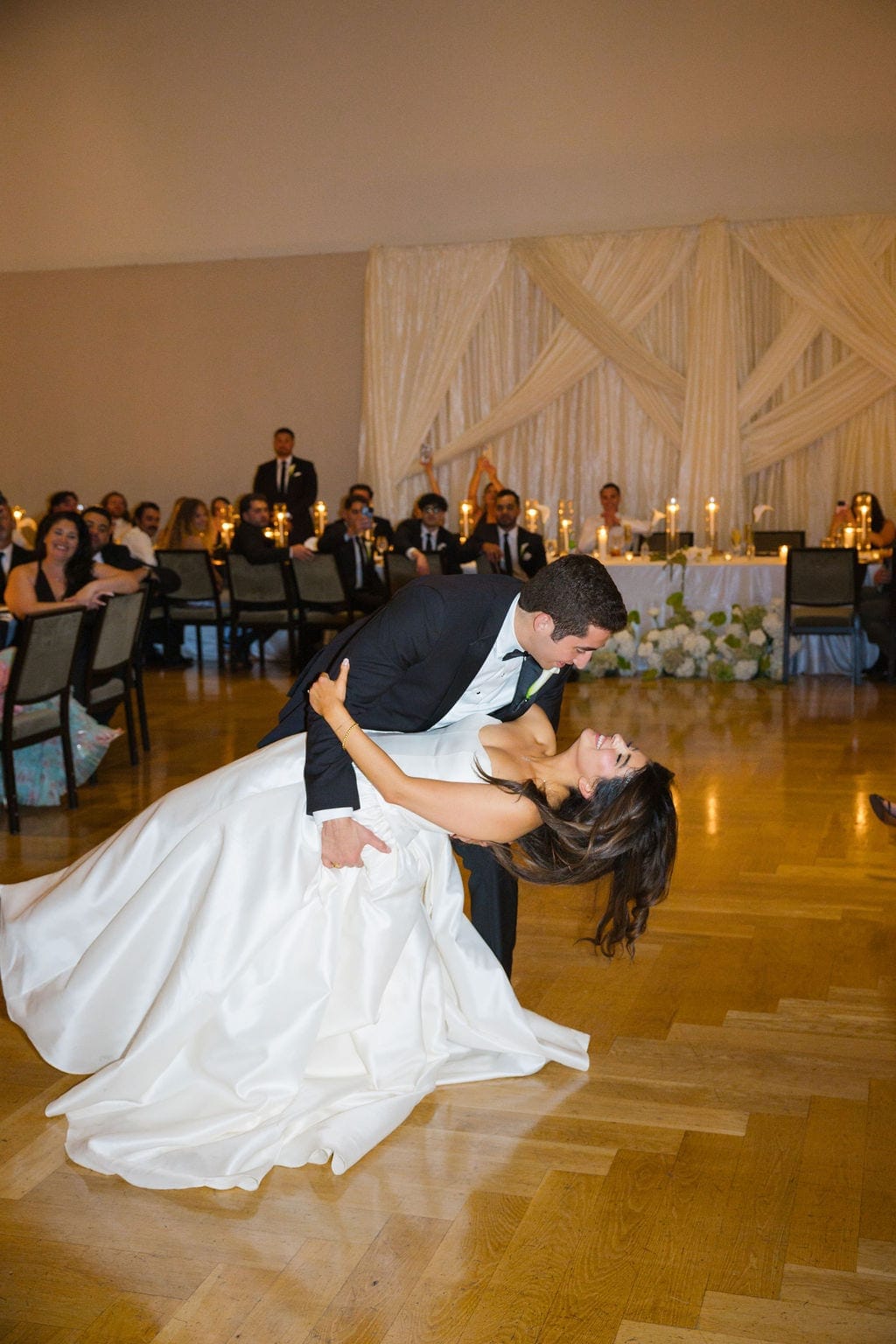 Groom dips bride during first dance ballroom reception