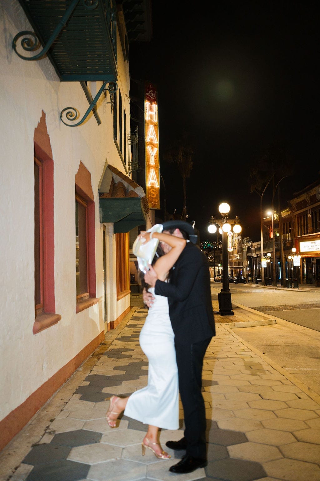 Bride and groom kiss Ybor city street night neon Tampa