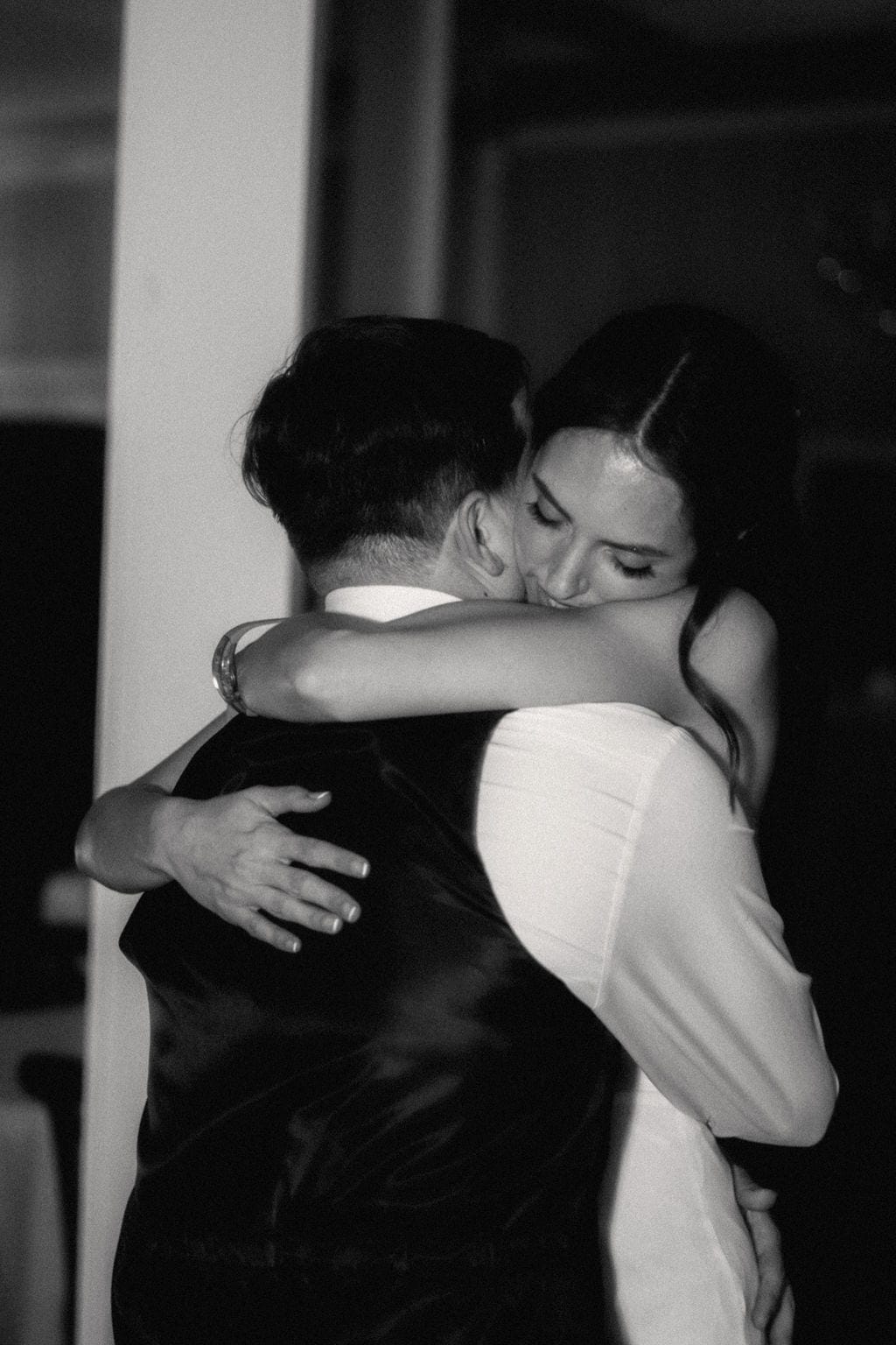 Bride embracing groom eyes closed reception black and white