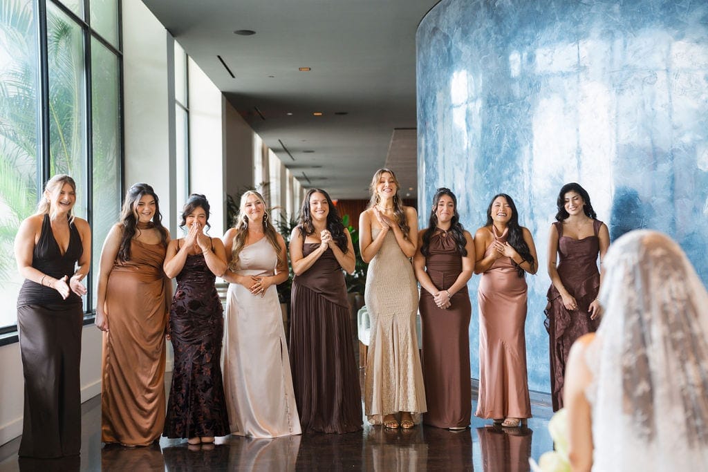 Bridesmaids first look reaction to bride hotel hallway