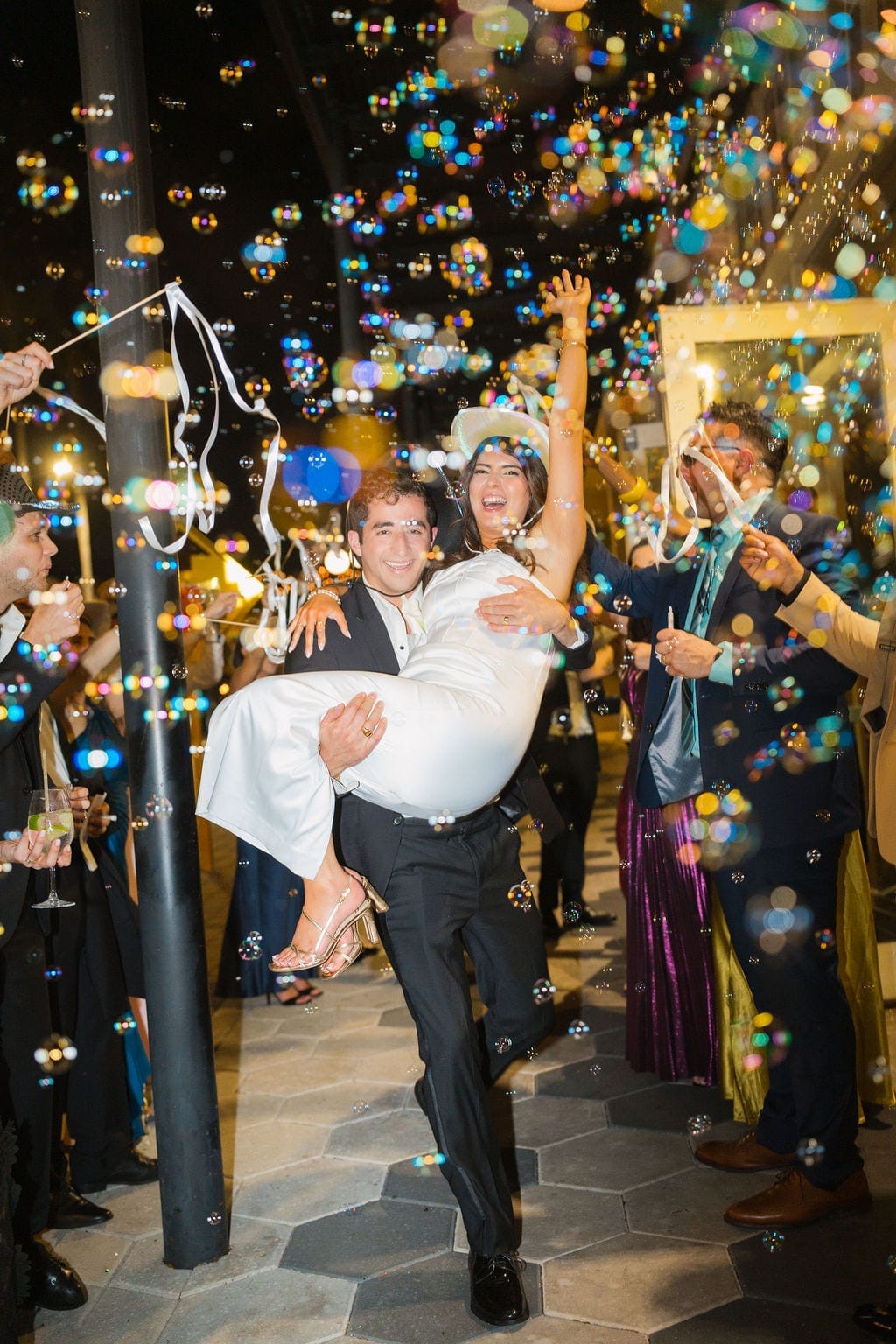 Groom carries bride through bubble exit night send off
