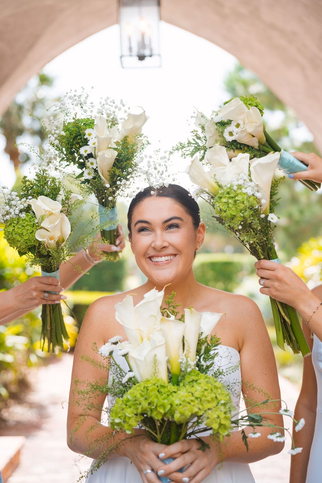 Bride framed by calla lily and green hydrangea bouquets
