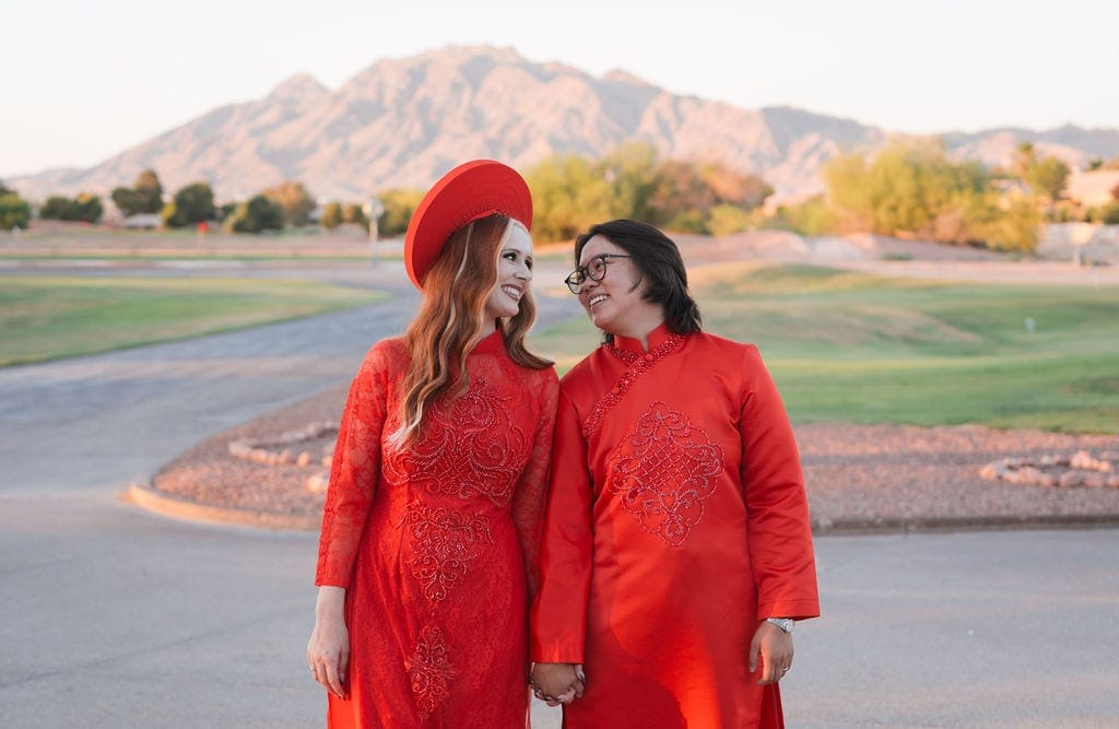 Couple in red traditional ao dai holding hands golden hour