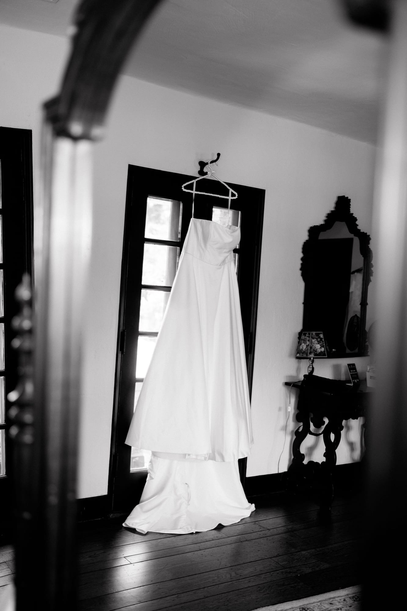 Wedding dress hanging in a doorway, black and white