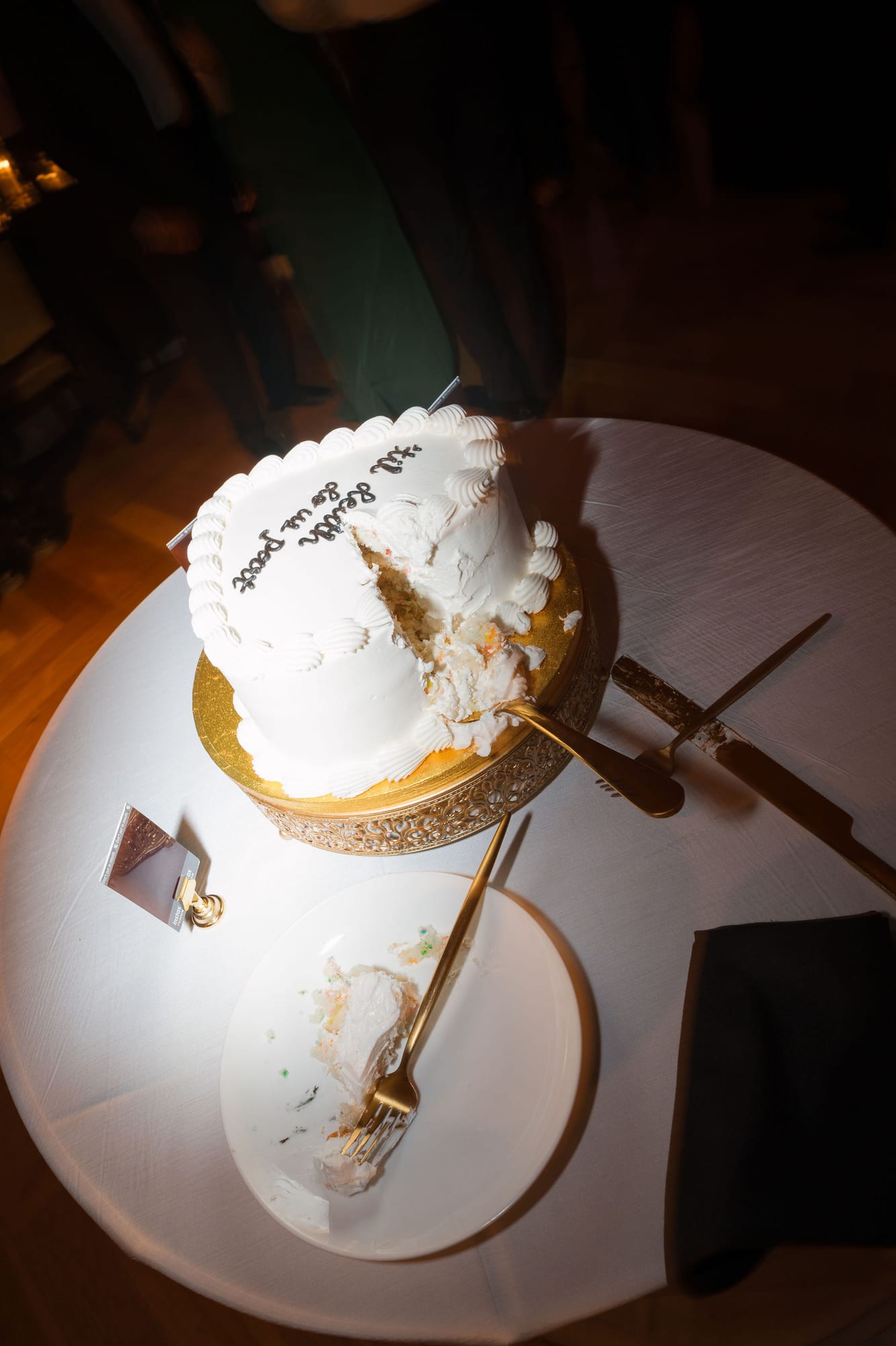 Wedding cake on a gold stand at a reception