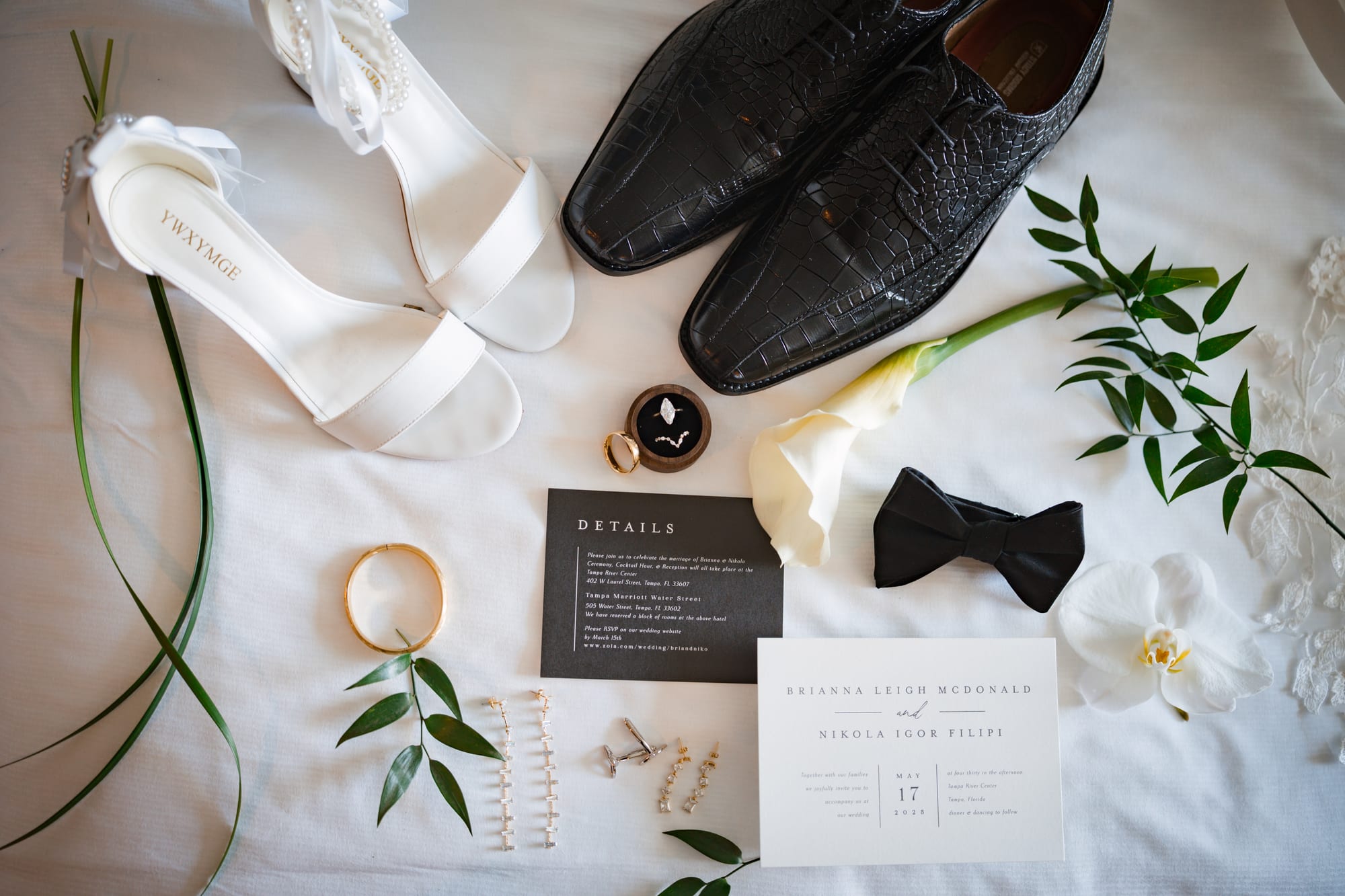 Wedding detail flat lay with shoes, rings, bowtie and invitation suite