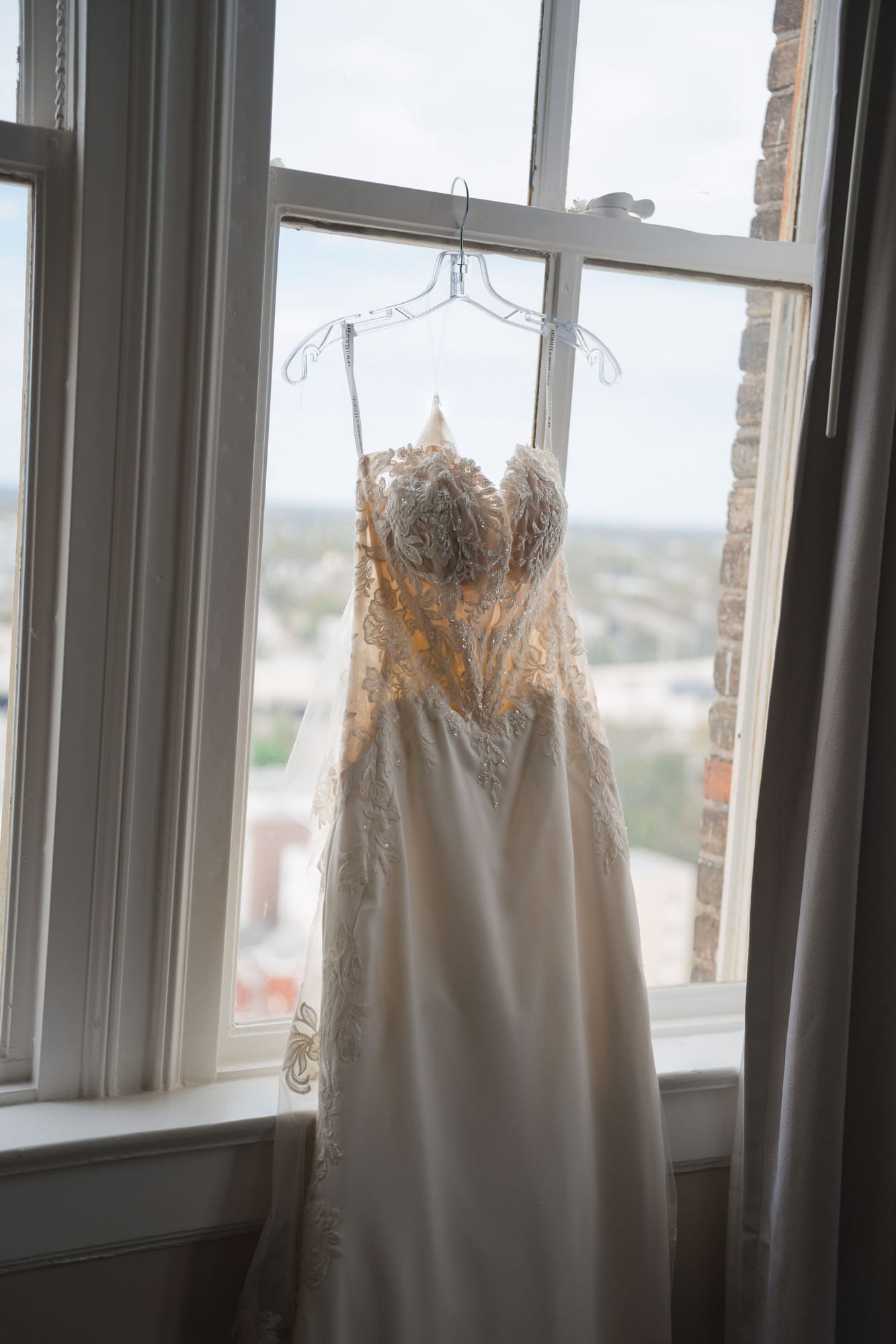 Wedding dress hanging in soft window light before a Tampa wedding