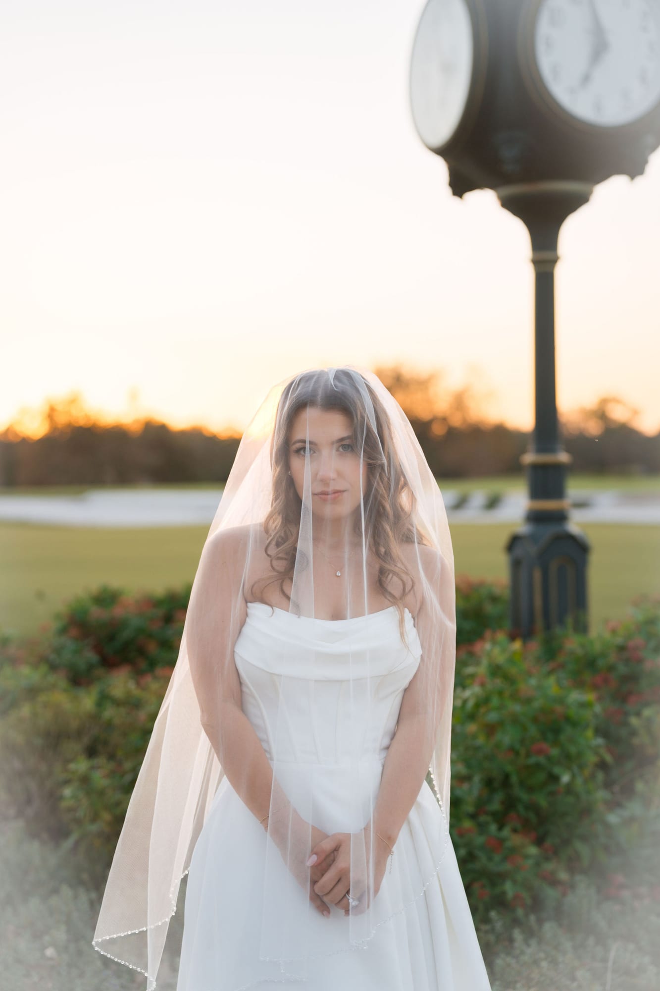 Bride at golden hour beside the clubhouse clock at Lakewood Ranch Golf and Country Club