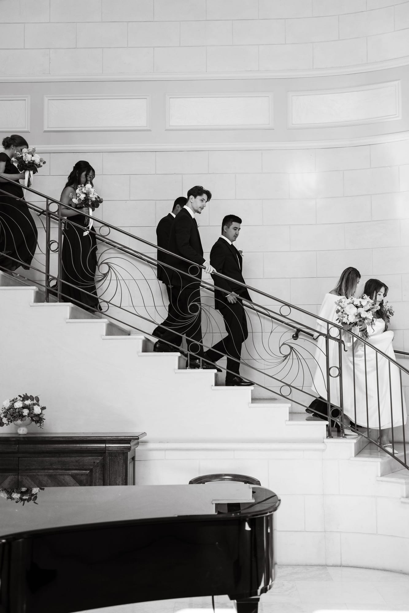 Bride and groom coming down the grand staircase into the ballroom
