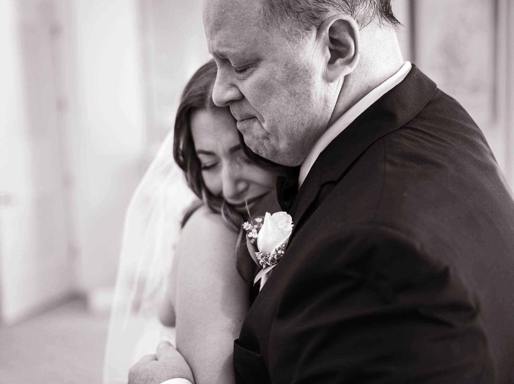 Emotional father of the bride hugging his daughter during their first look