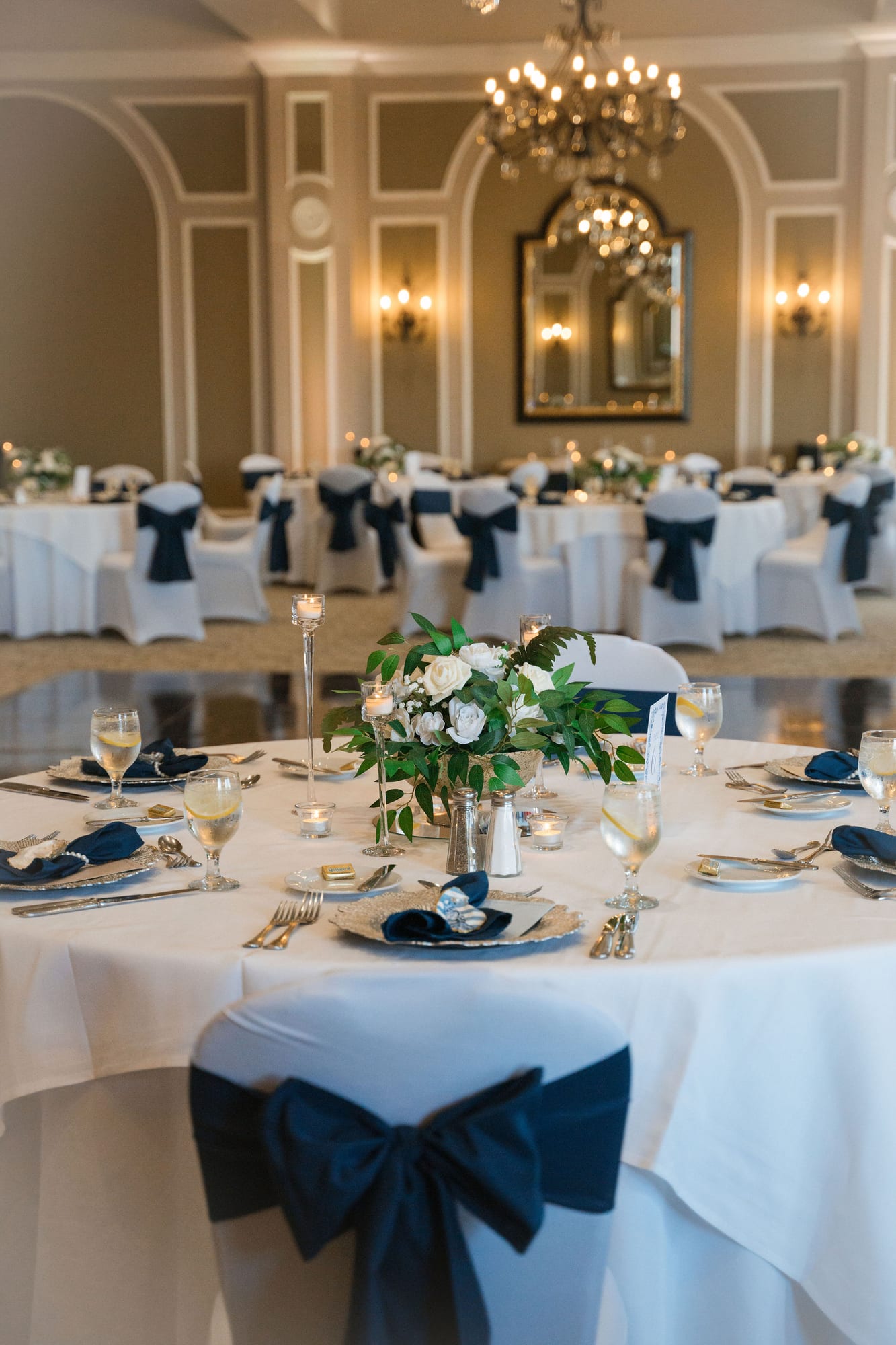 Reception tablescape with navy linens and white and blue florals in the ballroom