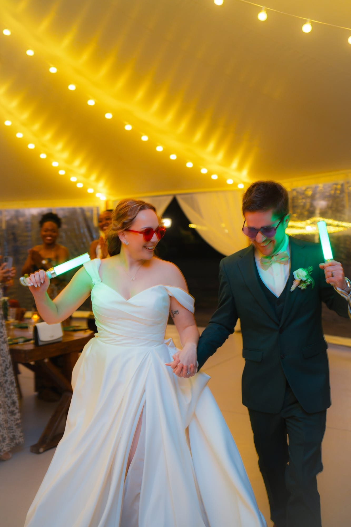 Bride and groom dancing with glow sticks and novelty sunglasses