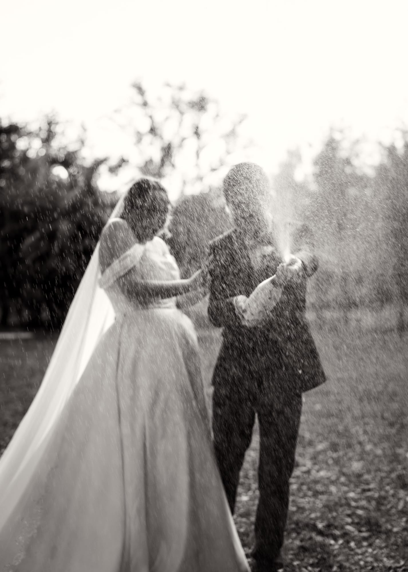 Bride and groom spraying champagne in black and white