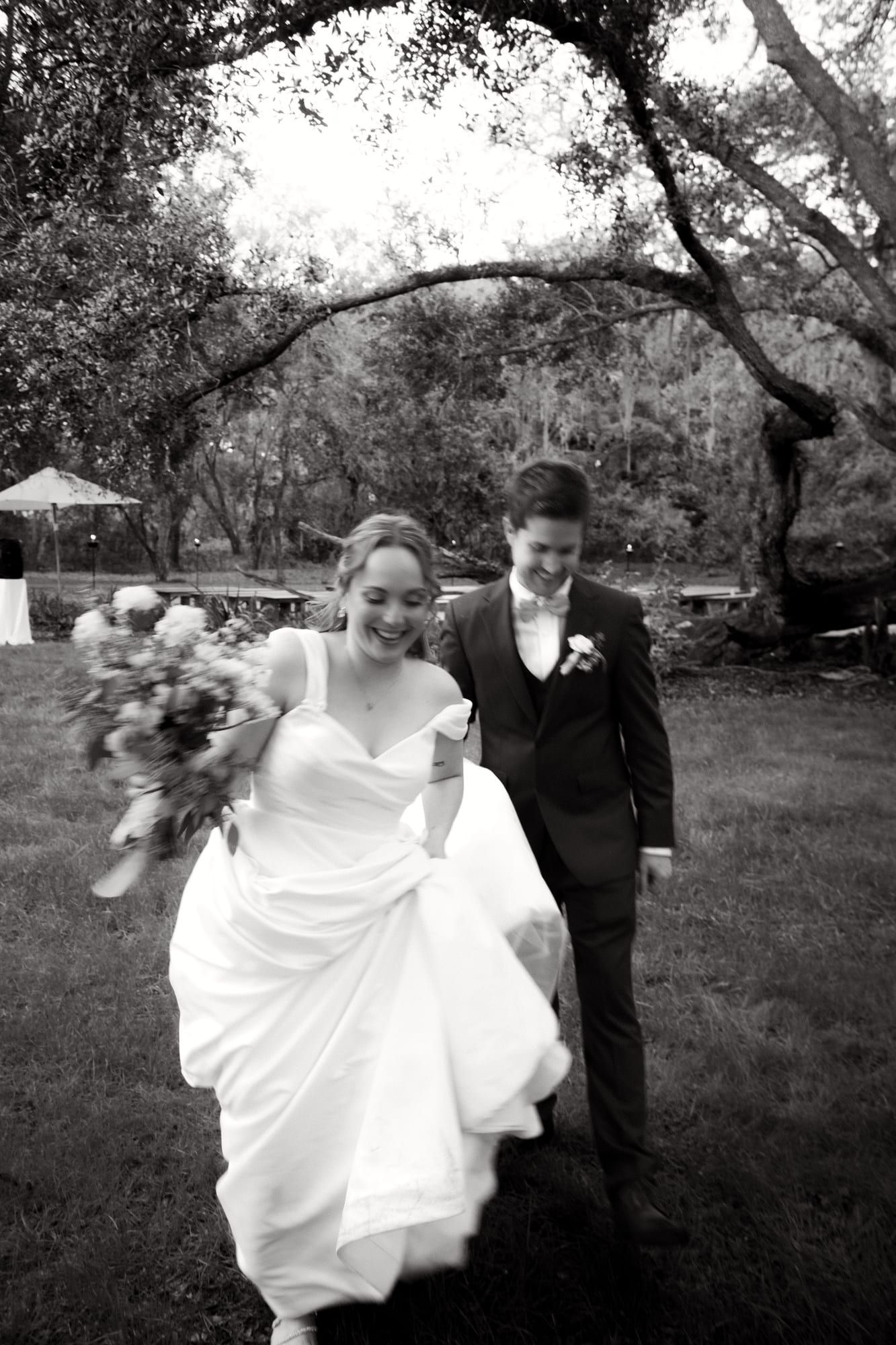 Bride and groom walking the grounds at Mill Pond Estate in black and white