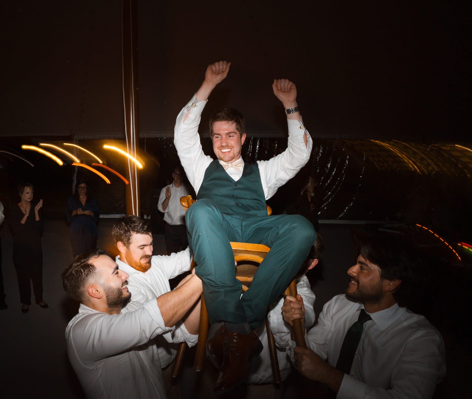 Groom lifted in a chair during the hora at the reception