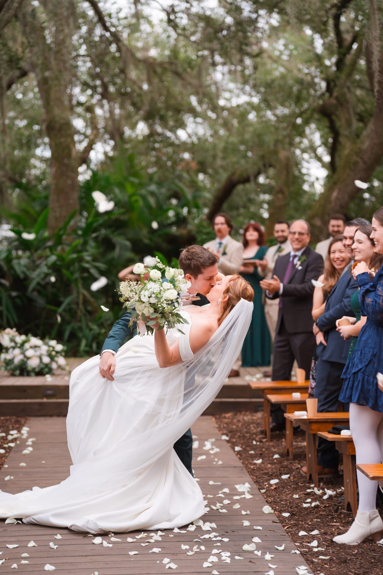 Newlyweds walking back up the aisle through a shower of flower petals