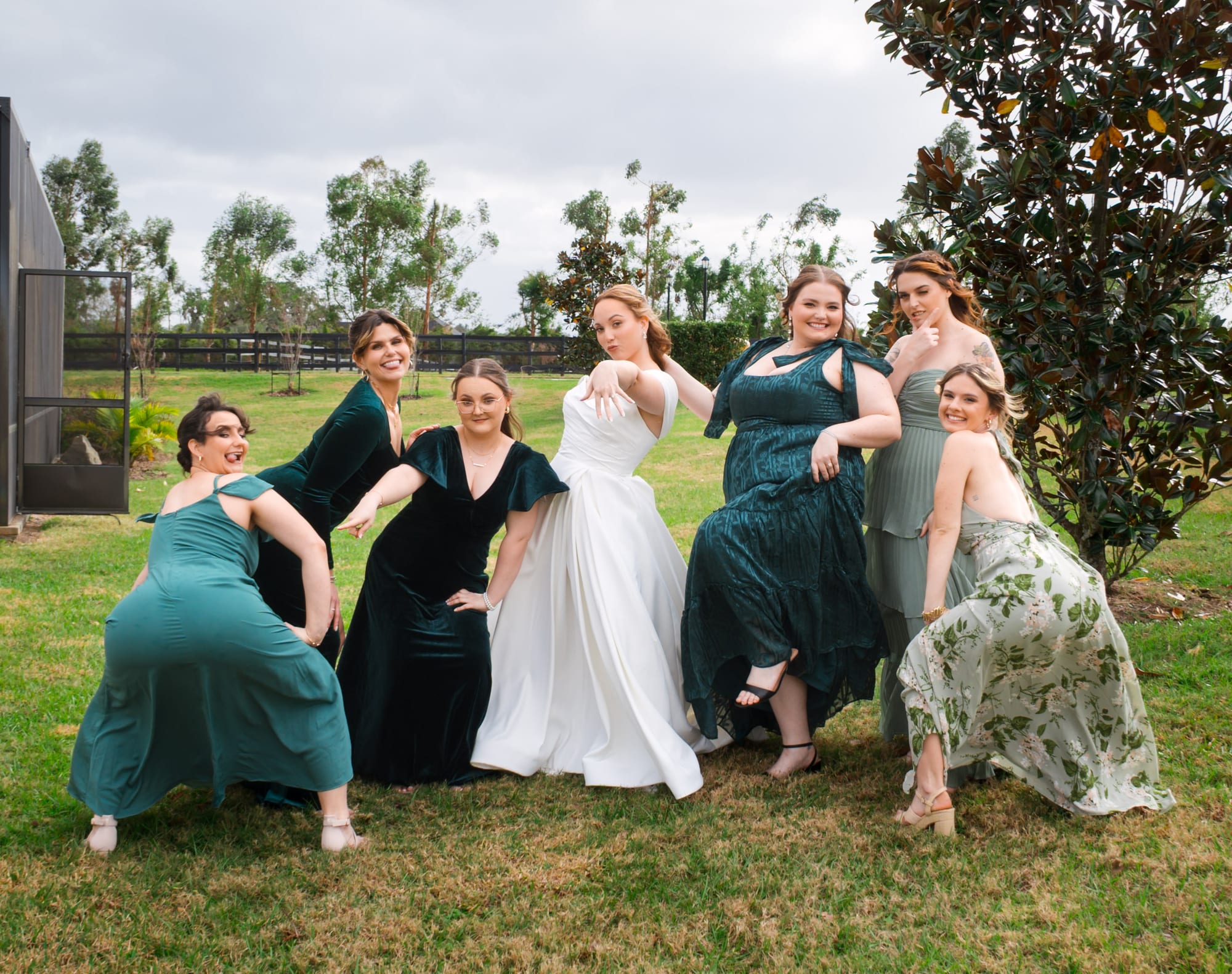 Wedding party posing on the lawn at Mill Pond Estate with the greenhouse behind them