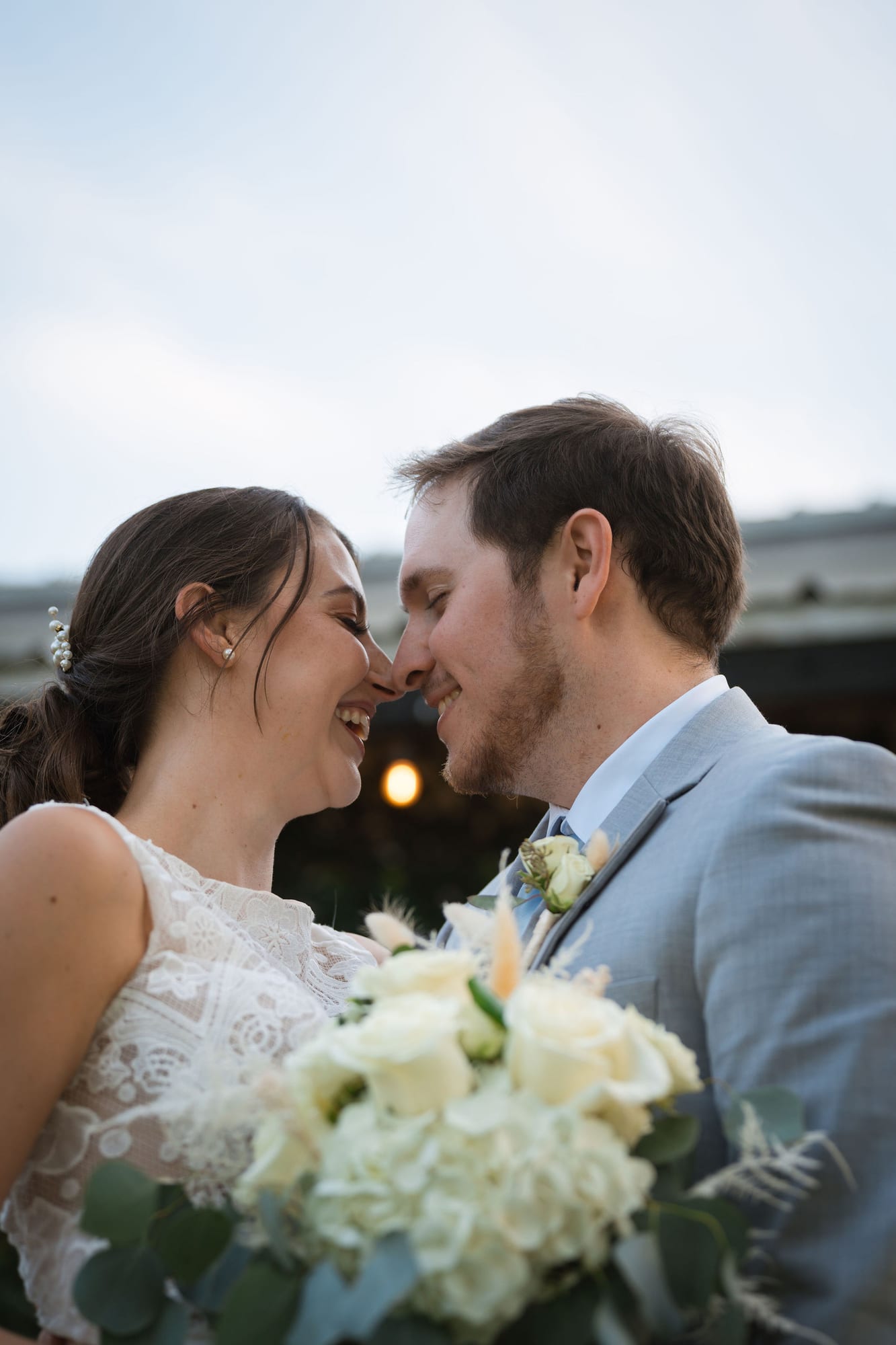 Bride and groom touching foreheads during their golden hour portraits