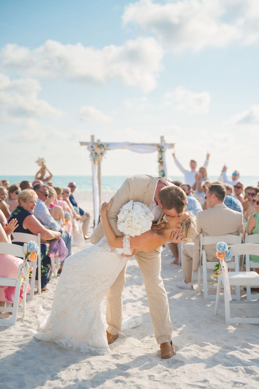 Groom dipping bride for a kiss at a Florida beach wedding ceremony