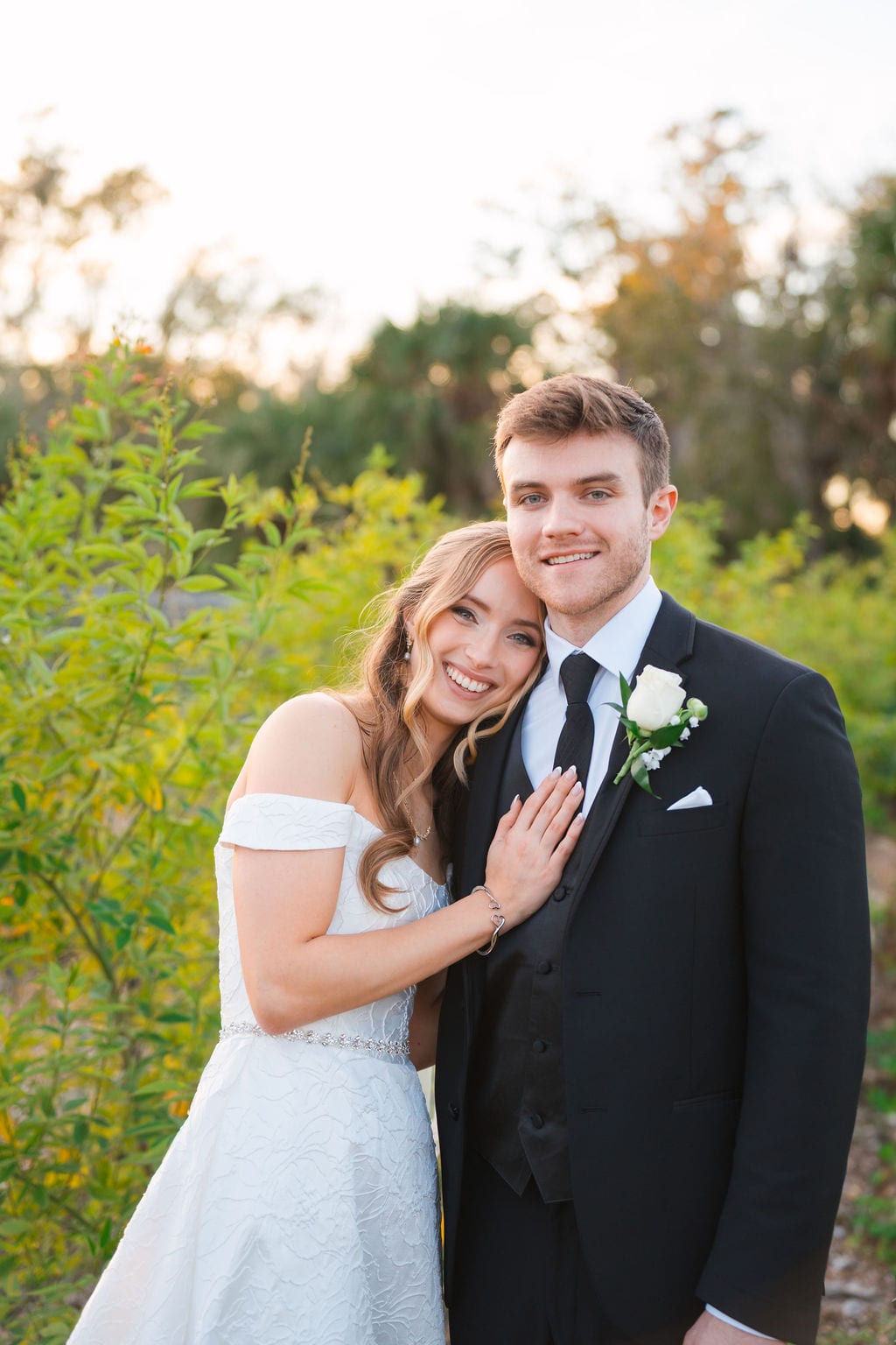 Bride and groom smiling during golden hour portraits with Florida greenery